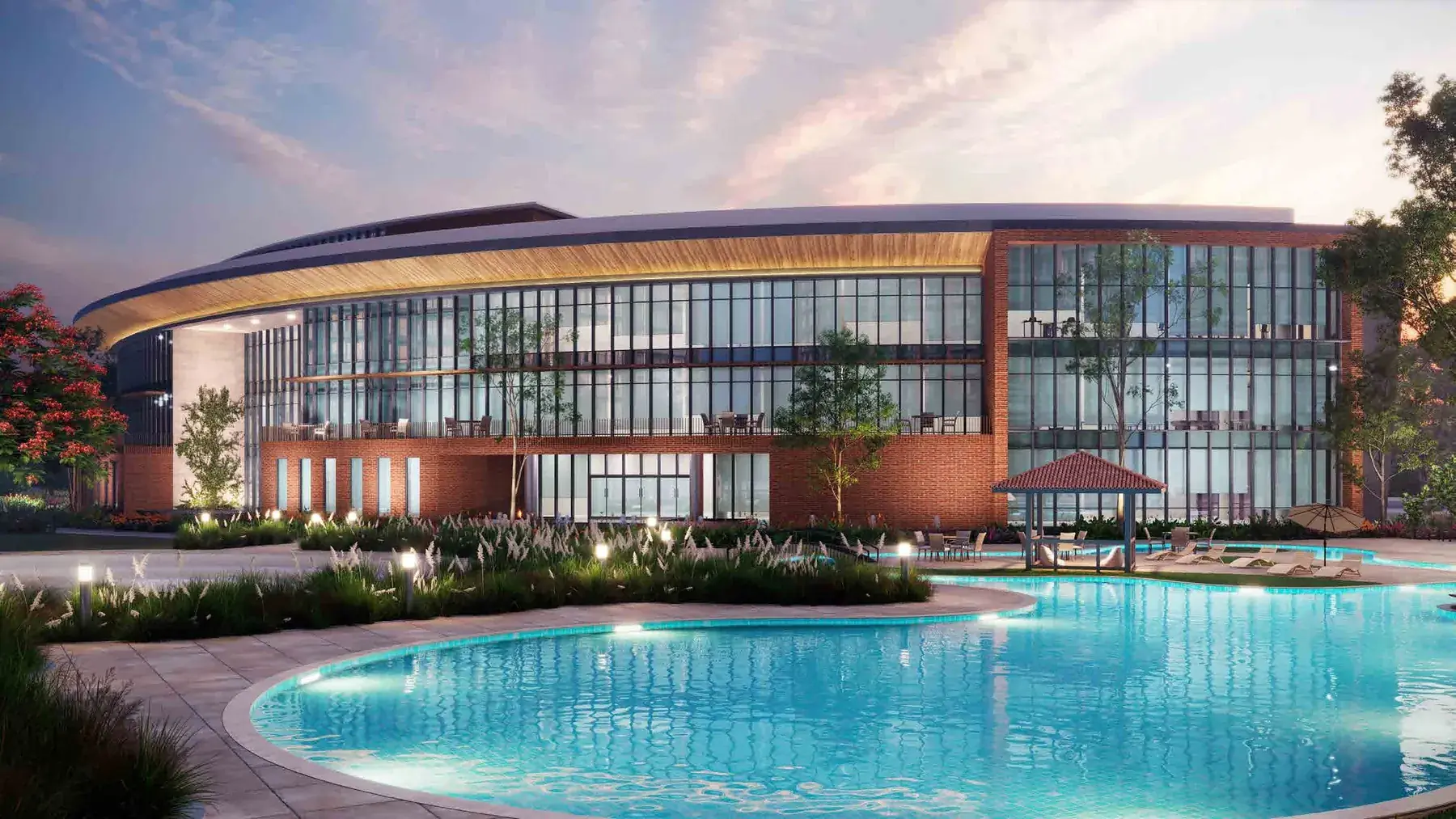 The curved eco-conscious clubhouse at SOBHA Aranya at dusk, seen across the pool. Artist's impression.